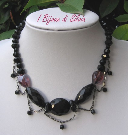 Girocollo "metal dark" realizzato con cristalli sfacettati neri, onice sfacettata, e cubetti neri in vetro veneziano e 2 cristalli a goccia color prugna. Catena color canna di fucile